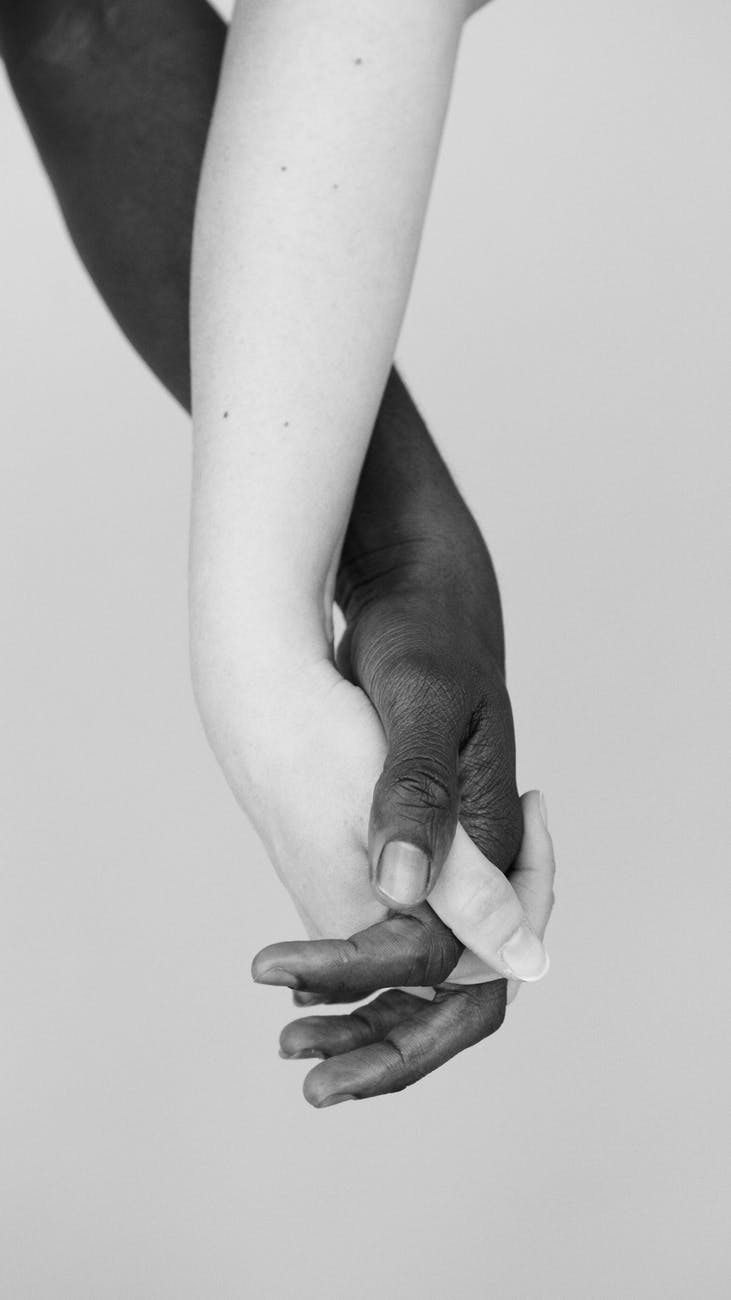 grayscale photo people holding hands